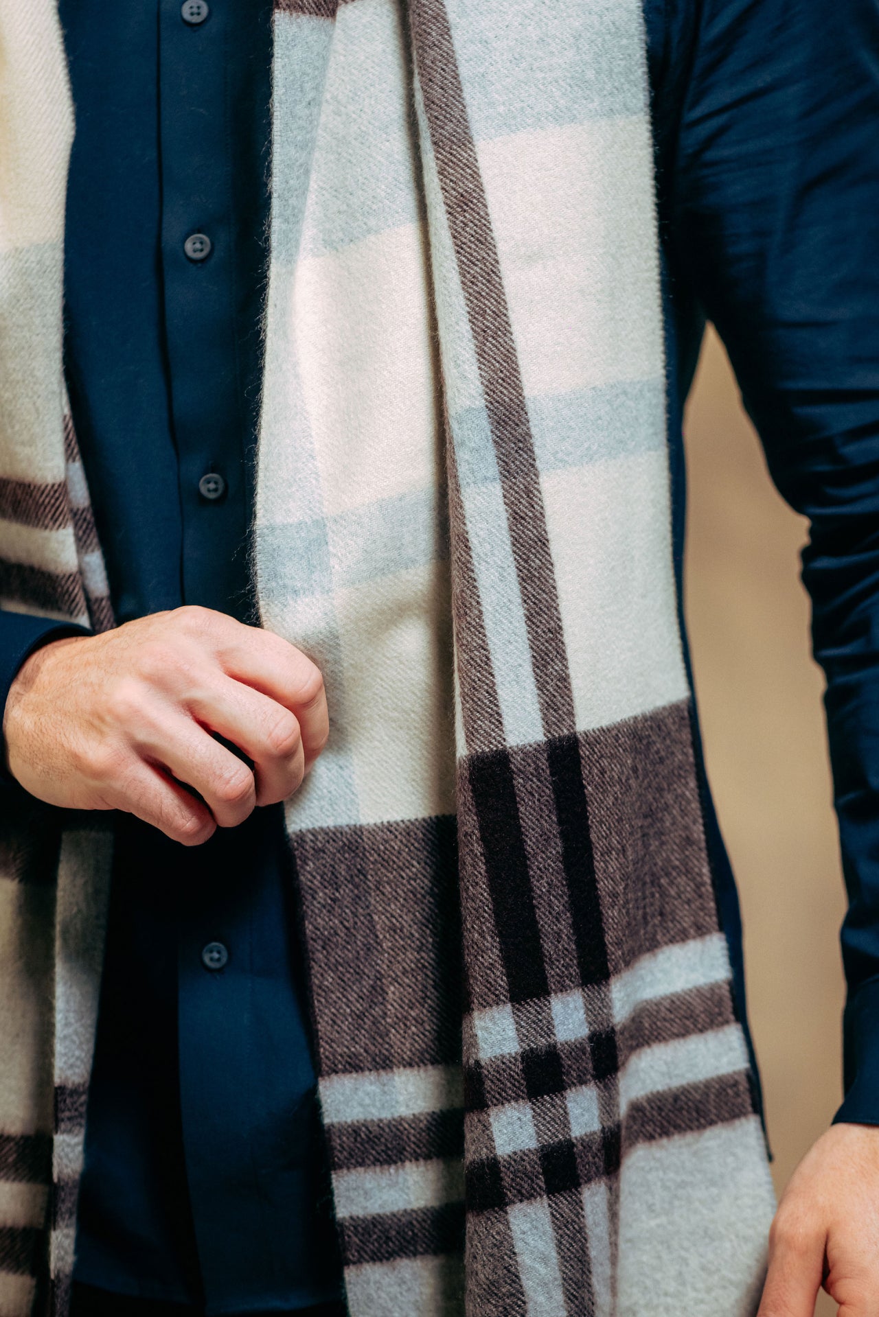 Person wearing a plaid cashmere  scarf with a neutral background