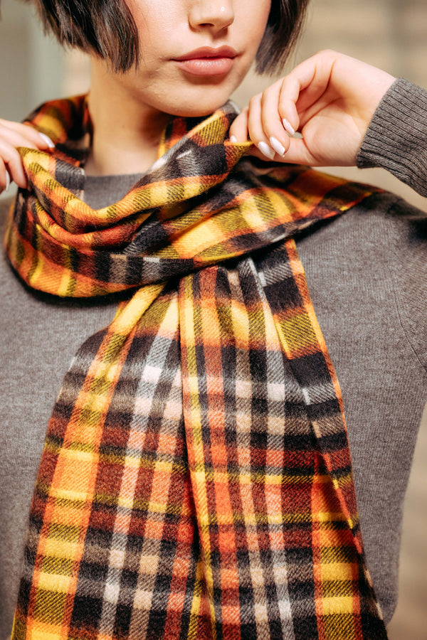 Person wearing a plaid cashmere scarf with a neutral background