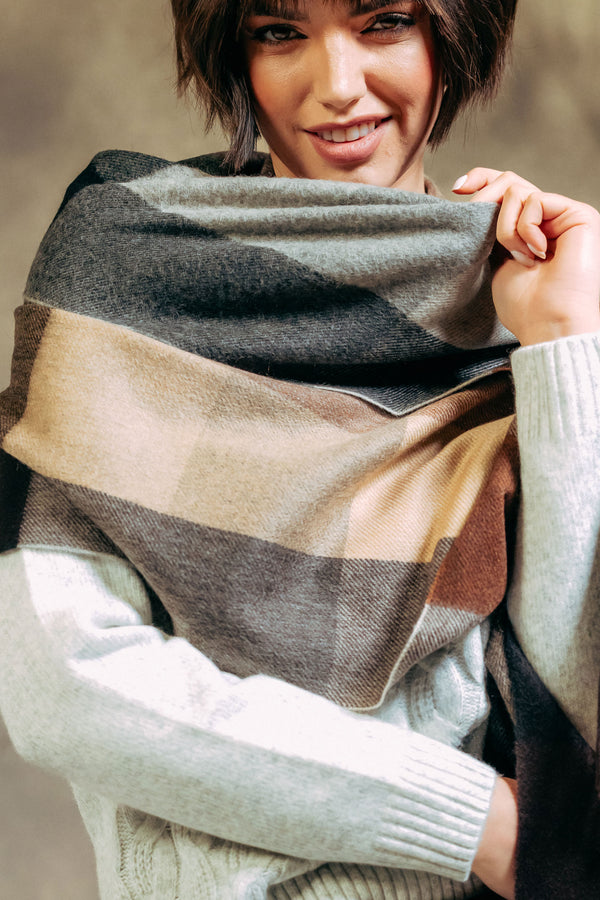 Woman wearing a striped scarf with a neutral background