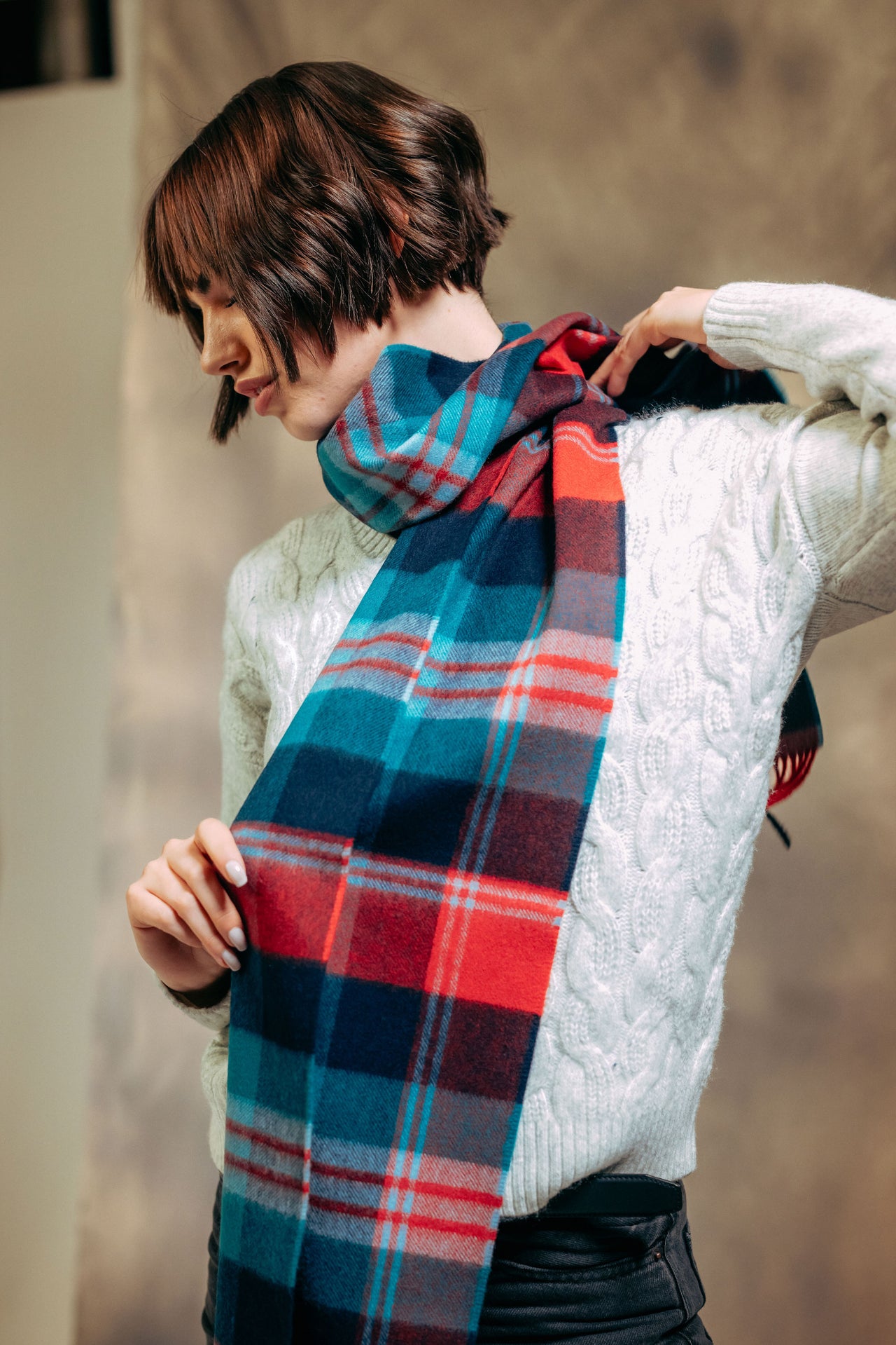 Person wearing a cashmere scarf with a neutral background