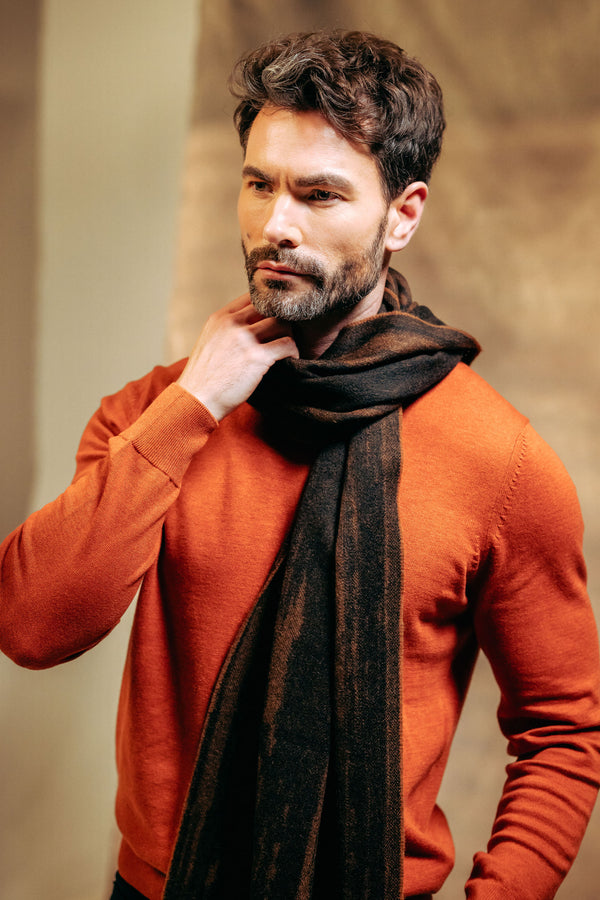 Man wearing a red sweater and cashmere scarf against a neutral background